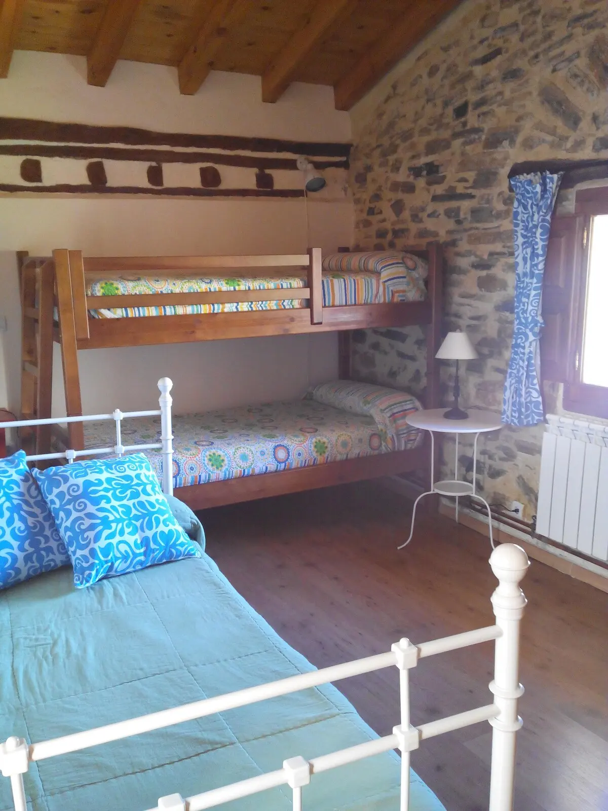 Dormitorio cuádruple con litera, bajo techo de vigas